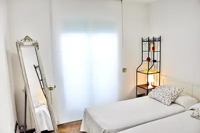 a bedroom with two beds and a mirror at Complex Vicor in Vilassar de Mar