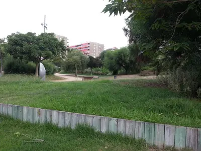 a park with a bench in the grass at Complex Vicor in Vilassar de Mar