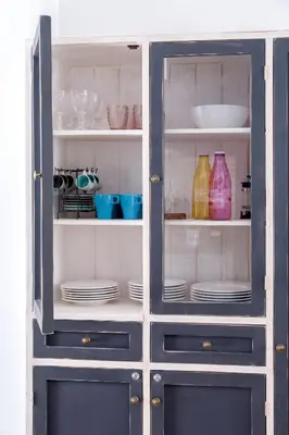 a blue cabinet with plates and dishes in it at Gracia 1872 in Barcelona