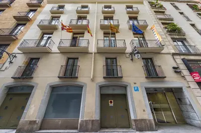 a tall building with windows and balconies at Hostal Operaramblas in Barcelona