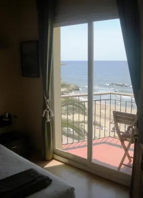 a bedroom with a view of the ocean from a window at Sitges Beach Panorama in Sitges
