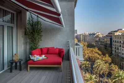 a red couch on the balcony of a building at Vincci Mae in Barcelona