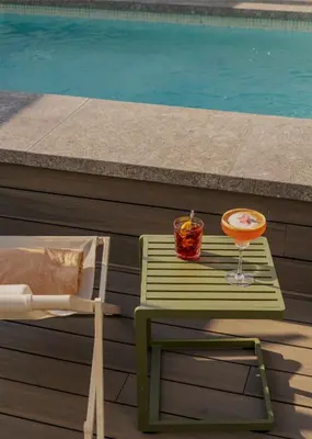 a green table with a drink on it next to a pool at Vincci Mae in Barcelona