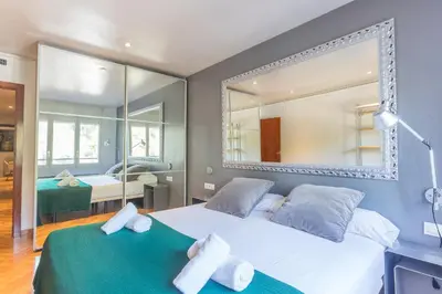 a bedroom with a large white bed and a mirror at Apartment Barcelona Rentals - Classic Bonanova Apartment in Barcelona