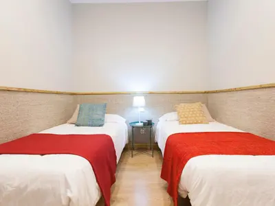 a room with two beds with red and white sheets at Cozy Gracia 2 bedrooms in Barcelona
