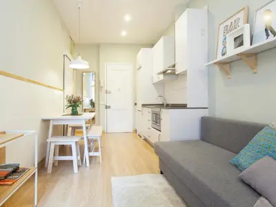 a living room with a couch and a table at Cozy Gracia 2 bedrooms in Barcelona