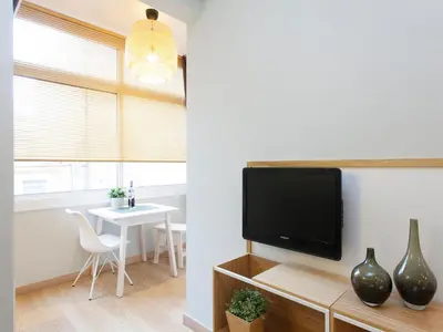 a living room with a tv and a table at Cozy Gracia 2 bedrooms in Barcelona