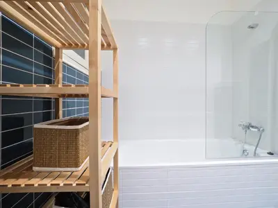 a bathroom with a wooden ladder next to a tub at Suites4days Plaça Catalunya Design in Barcelona