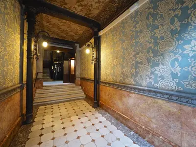 an empty hallway with a tile floor and blue and gold wallpaper at Suites4days Plaça Catalunya Design in Barcelona