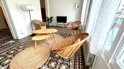 a living room with two tables and chairs and a tv at Suites4days Plaça Catalunya Design in Barcelona