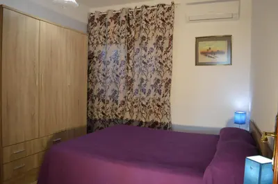 a bedroom with a purple bed and a curtain at Vista Cunit in Cubelles