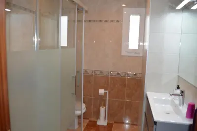 a bathroom with a shower and a toilet and a sink at Vista Cunit in Cubelles