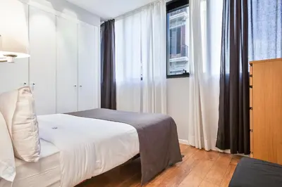 a bedroom with a white bed and a window at Bonavista Apartments - Passeig de Gracia in Barcelona