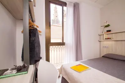 a small room with a bed and a window at Hostal Benidorm in Barcelona
