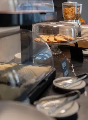 a table with plates of food and utensils on it at Hotel La Casa Del Sol in Barcelona