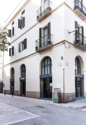 a white building with windows and balconies on a street at Hotel La Casa Del Sol in Barcelona