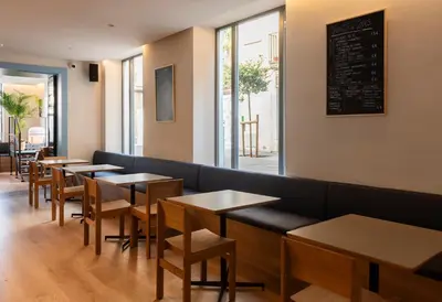 a restaurant with tables and chairs and a chalkboard on the wall at Hotel La Casa Del Sol in Barcelona
