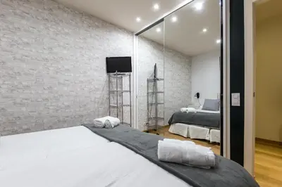 a bedroom with two beds and a mirror at Sarriá - Sant Gervasi in Barcelona
