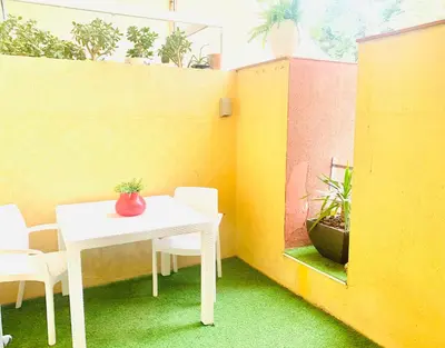 a white table and chairs in a room with plants at Panoramic Apartments Sitges in Sitges