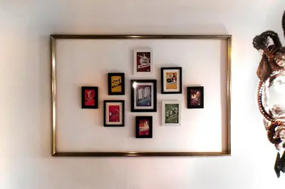 a mirror hanging on a wall with framed pictures at Casa Tortilla Gracia in Barcelona