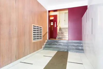 a hallway with stairs and a red door at Habitat Apartments Garden View in Barcelona