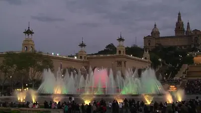 a group of people standing around a fountain in front of a building at Unique Cozy Scenic Penthouse in Barcelona