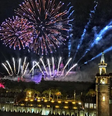 a fireworks display over a building with a tower at Unique Cozy Scenic Penthouse in Barcelona