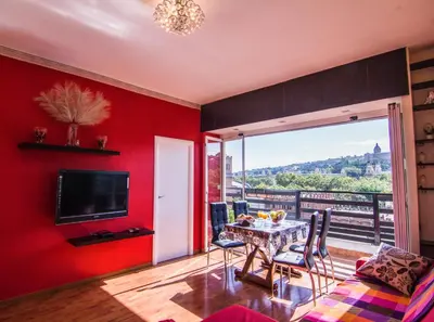 a living room with red walls and a table and chairs at Unique Cozy Scenic Penthouse in Barcelona