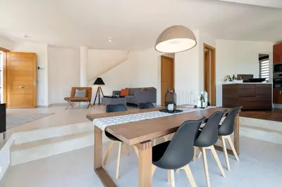 a dining room and living room with a table and chairs at Luxury Sitges Hills Villa in Olivella