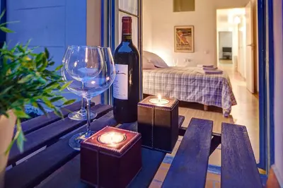 a bottle of wine and a glass and candles on a table at Habitat Apartments Bruc Terrace in Barcelona