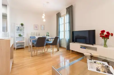 a living room with a table with chairs and a television at Sibs Bcn- Balmes- Romantic CityCentre Beautiful in Barcelona