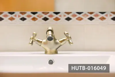 a bathroom sink with a brass faucet at Elegant Sitges Apartment in Sitges