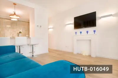 a living room with a blue couch and a tv at Elegant Sitges Apartment in Sitges