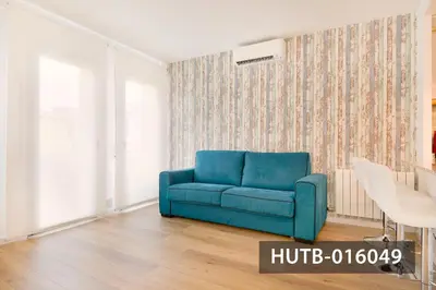 a blue couch in a living room with a wallpaper at Elegant Sitges Apartment in Sitges