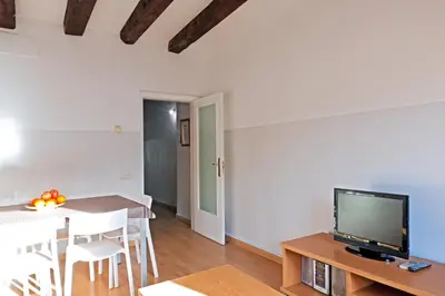 a living room with a tv and a table with a dining room at My Address in Barcelona Downtown in Barcelona