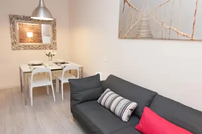 a living room with a black couch and a table at Charming Gracia 2 bedrooms in Barcelona