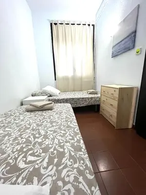 a small room with two beds and a dresser at Camp Nou Apartment WiFi in Barcelona