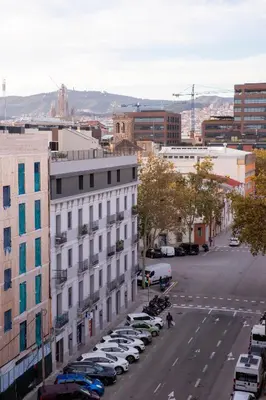 a city street with cars parked in a parking lot at DragonTree Barcelona - apartamentos turisticos 5 min from the BEACH in Barcelona