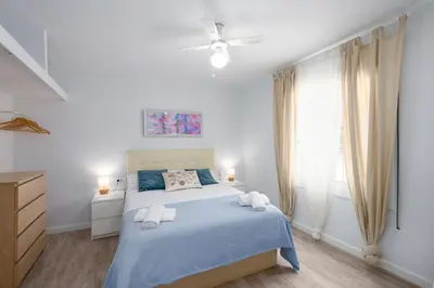 a bedroom with a blue bed with two towels at Apartamento Manent in Premiá de Mar