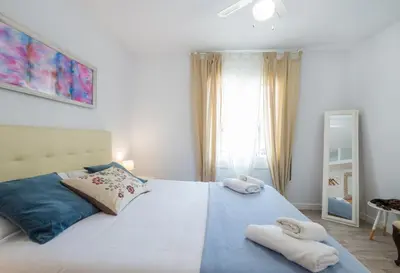 a bedroom with a large white bed with towels on it at Apartamento Manent in Premiá de Mar
