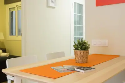 an orange mat on a table with a plant on it at Contemporary Apartment Near Camp Nou and Fira Barcelona in Hospitalet de Llobregat