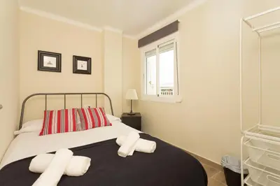 a bedroom with a bed with two towels on it at Contemporary Apartment Near Camp Nou and Fira Barcelona in Hospitalet de Llobregat