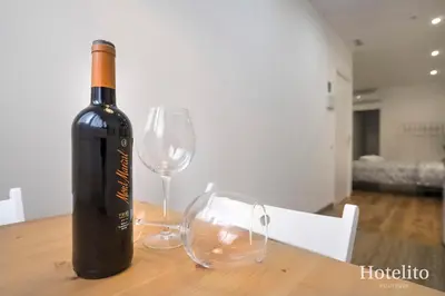 a bottle of wine and two glasses on a table at Hotelito Boutique Camp Nou in Hospitalet de Llobregat
