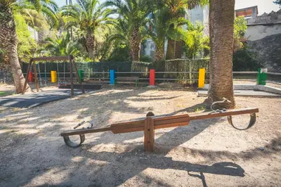 a park with a bench next to a tree at HolaCamp Sitges Relax in Sitges