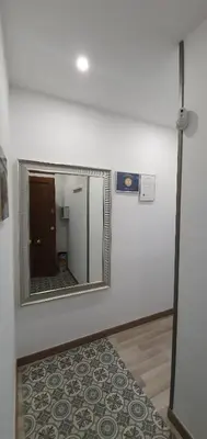 a mirror on a wall with a rug in a room at APARTAMENTS B O D CoLLBLANC in Hospitalet de Llobregat