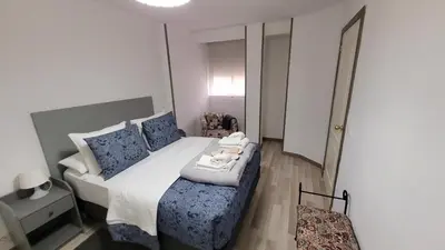 a small bedroom with a bed with blue pillows at APARTAMENTS B O D CoLLBLANC in Hospitalet de Llobregat