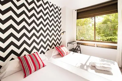 a bedroom with two beds and a checkered wall at Fira Guest House in Barcelona