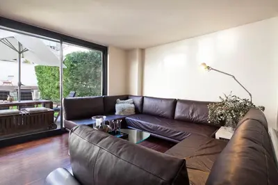 a living room with a brown leather couch at Apartment Barcelona Rentals - Private Pool and Garden Center in Barcelona