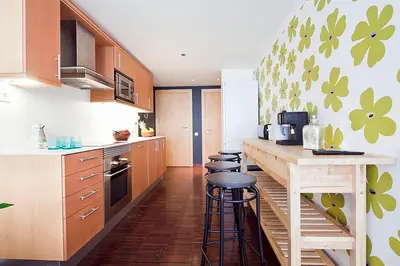 a kitchen with wooden cabinets and a counter with stools at Apartment Barcelona Rentals - Private Pool and Garden Center in Barcelona