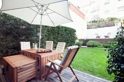 a patio with a table with an umbrella and chairs at Apartment Barcelona Rentals - Private Pool and Garden Center in Barcelona